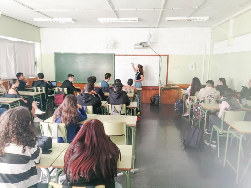 Vemos desde el fondo de un aula de instituto llena de alumnado cómo se desarrolla un taller